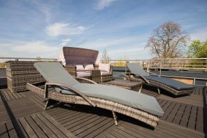 eine Terrasse mit zwei Korbstühlen und einem Liegestuhl in der Unterkunft Lodgepark Goitzsche GmbH in Große Mühle
