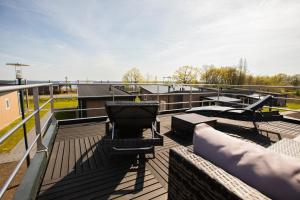 a roof deck with a grill and chairs on it at Lodgepark Goitzsche GmbH in Große Mühle