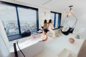 eine Gruppe von drei Frauen, die in einem Zimmer mit Fenstern sitzen in der Unterkunft Zonar Zagreb by Maistra City Vibes in Zagreb