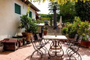 a patio with a table and chairs and an umbrella at La Moiana in San Quirico dʼOrcia