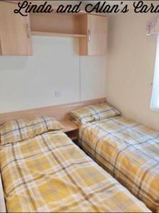 a room with two beds in a room at Linda/Alan's Happy Holiday Home in Rhyl