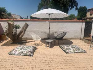 patio z 2 krzesłami, parasolem i poduszkami w obiekcie Villa Marquise w mieście Canet-en-Roussillon
