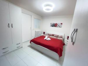 a white bedroom with a red bed with a red blanket at Ferrari Holiday House - Casa Vacanza nel cuore di Campobasso in Campobasso
