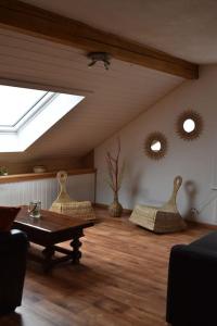 a living room with a skylight and a table and chairs at Appartement Chez l'apiculteur in Travers