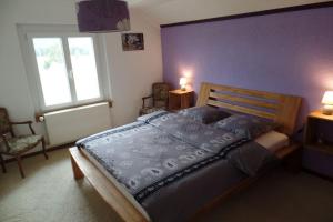1 Schlafzimmer mit einem großen Bett und 2 Stühlen in der Unterkunft Appartement Chez l'apiculteur in Travers