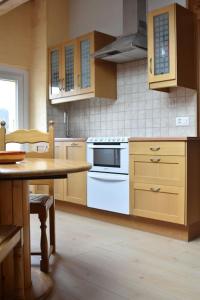 cocina con horno blanco y mesa en Appartement Chez l'apiculteur, en Travers
