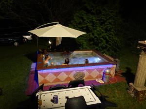 un grupo de personas en una piscina por la noche en Hill View Holiday House nearby Budapest with AC & Pool, en Pilisszentiván