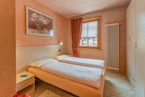 een kleine slaapkamer met een bed en een raam bij Appartamenti Stefano in Livigno