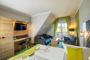 een hotelkamer met een bed en een woonkamer bij Panorama Berghotel Wettiner Höhe in Seiffen