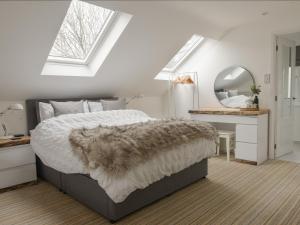 um quarto com uma cama, um espelho e uma secretária em Abode em Axminster