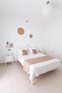 a white bedroom with two beds and two tables at Sorocada Private House in Akrotiri