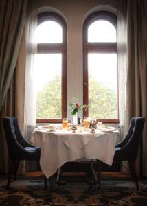 a table in a room with two windows at Hotel Kämp in Helsinki