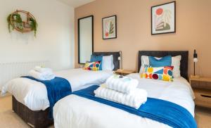 Beautiful 3 Bedroom Townhouse في هاروغايت: غرفة نوم بسريرين عليها مناشف