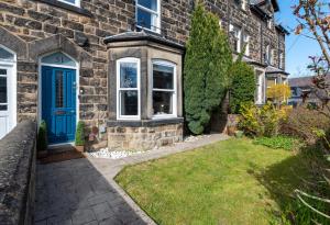 a brick house with a blue door and a yard at Beautiful 3 Bedroom Townhouse in Harrogate