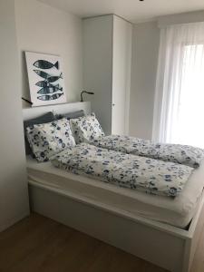 een slaapkamer met een bed met blauwe en witte lakens en een raam bij Alexandra 405 in De Panne
