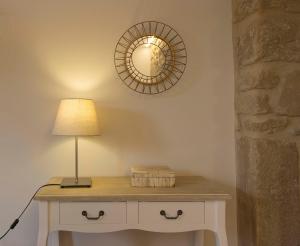 a table with a lamp and a mirror on a wall at El Mirador de Eloísa in Rodezno