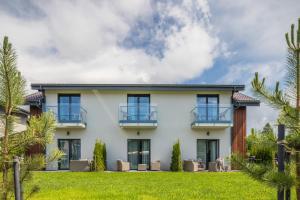 a house with a lawn in front of it at GENIO 7 apartamentai in Palanga