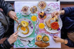 un grupo de personas sentadas en una mesa con alimentos para el desayuno en B&B La Cornice, en San Gimignano