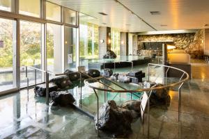 a lobby with a glass table and some rocks at Enakyo Onsen Hotel Yuzuriha in Ena