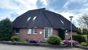 a red brick house with a black roof at Haus Katharina Ferienwohnung 1 in Cuxhaven