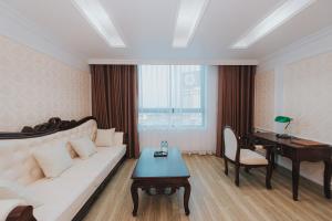 a living room with a white couch and a piano at Asean Hotel in Hải Dương