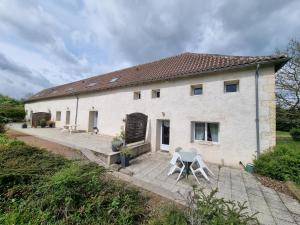 a white house with a table and a chair at Amazonite - 6 à 8 couchages in Archigny