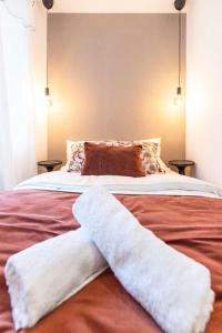 een slaapkamer met een groot bed en 2 witte handdoeken. bij Bliss - Résidence Hestia in Saint-Étienne