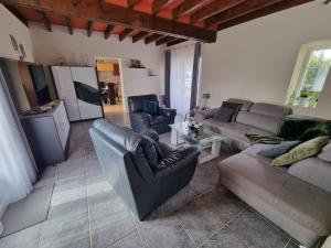 a living room with two couches and a kitchen at Amazonite - 6 à 8 couchages in Archigny