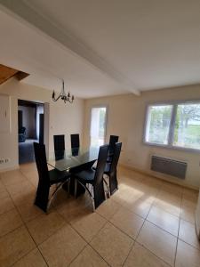 a dining room with a black table and chairs at Amazonite - 6 à 8 couchages in Archigny