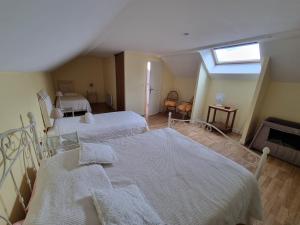 a attic bedroom with two beds and a window at Amazonite - 6 à 8 couchages in Archigny +21 photos