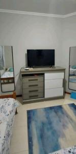 a living room with a tv and a dresser at Linda Cobertura em bombinhas com lazer privativo 200 metros da praia in Bombinhas +34 photos