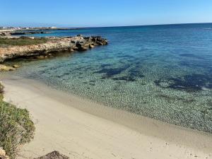 una spiaggia con acqua cristallina e rocce di Appartamenti in Villa Calamoni a Favignana