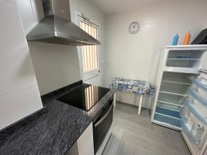a kitchen with a counter top and a refrigerator at Gran apartamento céntrico y muy cerca de la playa in Fuengirola