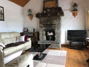 a living room with a couch and a stone fireplace at Rose Cottage in Greencastle
