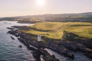 an aerial view of a lighthouse next to the ocean at Rose Cottage in Greencastle