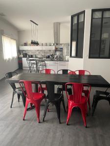 uma grande mesa de jantar com cadeiras vermelhas numa cozinha em Casa Oliva -situé au 2ème étage sans ascenseur em Perpignan