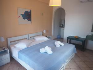 a bedroom with a bed with towels on it at Asterias Mini Coastal Apartments in Perivolos