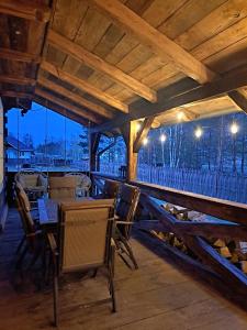 a patio with tables and chairs and a wooden ceiling at Sosnowy Domek in Harasiuki