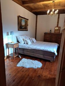 a bedroom with a bed and a table with a night stand at Sosnowy Domek in Harasiuki