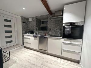 eine Küche mit Küchengeräten aus Edelstahl in einem Zimmer in der Unterkunft JobelHome Alb Apartment in Bad Urach