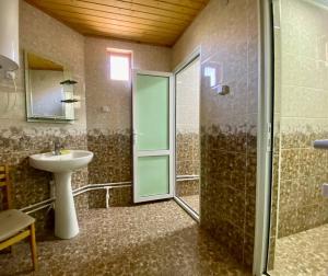 un bagno con lavandino e doccia con porta in vetro di Mountain Base ARTUCH a Panjakent