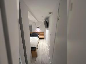 ein kleines Zimmer mit einem Bett und einem Flur in der Unterkunft JobelHome Alb Apartment in Bad Urach