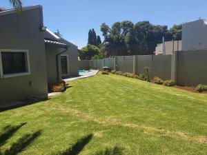 un patio de una casa con una valla en URlyfstyle 5 bedrooms near OR Tambo international Airport en Kempton Park