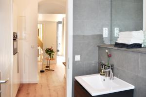 a bathroom with a sink and a counter with a mirror at Stylish New Cube Loft by Berlin-Wall-Apartments in Berlin