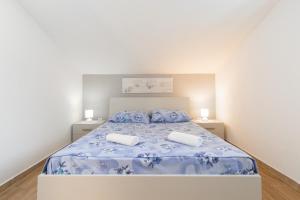 ein Schlafzimmer mit einem Bett mit zwei Kissen darauf in der Unterkunft House Rosa - Holiday Home70 metres away from Picena Beach in Vela Luka