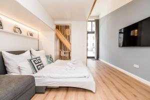 a living room with a bed and a tv at Stylish New Cube Loft by Berlin-Wall-Apartments in Berlin