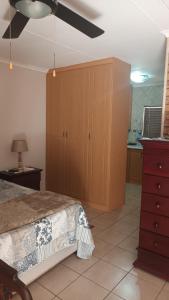 um quarto com uma cama e uma ventoinha de tecto em Lushof Guesthouse em Witbank