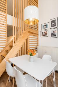 une salle à manger avec une table blanche et des chaises blanches dans l'établissement Stylish New Cube Loft by Berlin-Wall-Apartments, à Berlin 16 autres photos