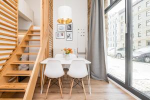 a dining room with a white table and white chairs at Stylish New Cube Loft by Berlin-Wall-Apartments in Berlin