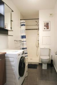 een badkamer met een wasmachine en een toilet bij Brand new studio with an open view on Paris in Arcueil